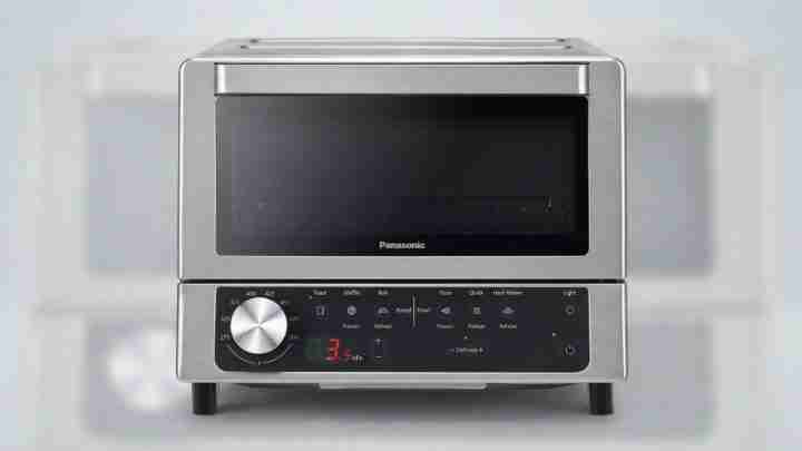 Panasonic stainless steel microwave/oven with a large front door and digital control panel beneath it both in a modern kitchen appliance.